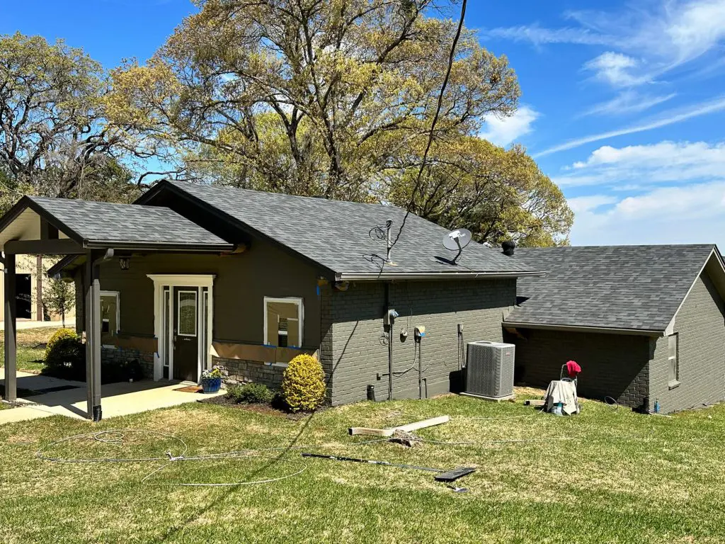 Painters in Longview, Tx, Expert exterior house painting and prep work, applying a custom dark gray/olive color to the siding and trim of a residential home in the Tyler, TX area.