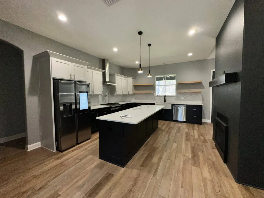Expert two-tone kitchen cabinet painting and refinishing by Z&A, showcasing black and white cabinetry with a custom gray wall color in a modern luxury home in Tyler, TX.